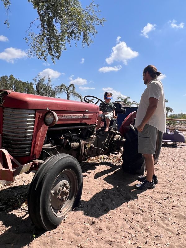 Founder and son operating tractor at AI Sustainable Foods demonstrating hands-on technology and equipment operations on 18-acre closed-loop farm Saylorsburg Pennsylvania